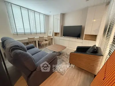Modern living room with stylish furniture and large TV, perfect for relaxation.