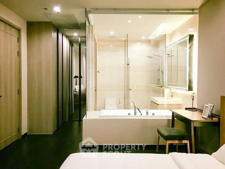 Luxurious modern bedroom with integrated bathroom featuring a sleek bathtub and elegant lighting.