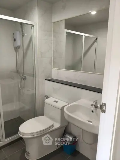 Modern bathroom with shower enclosure and sleek fixtures in a contemporary apartment.