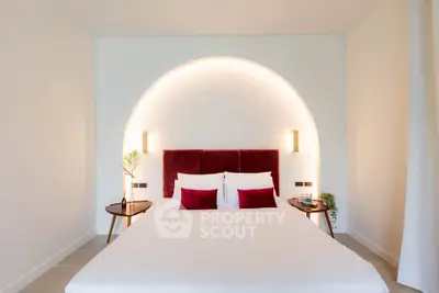 Elegant bedroom with modern lighting and plush red accents