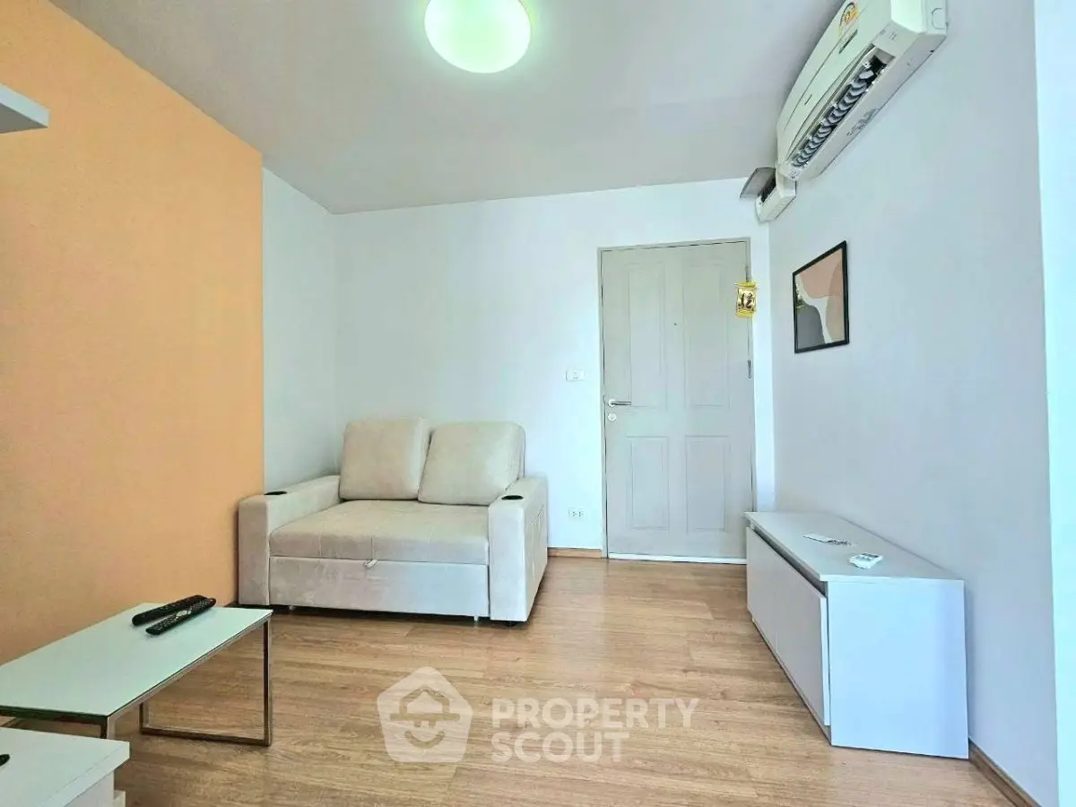Cozy living room with modern furniture and air conditioning, perfect for relaxation.
