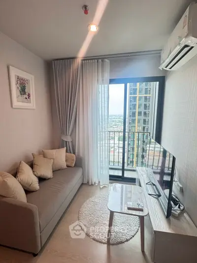 Cozy living room with modern decor and balcony view in high-rise apartment.