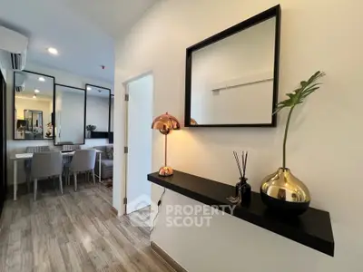 Modern living room with elegant decor and dining area, featuring stylish lighting and wooden flooring.
