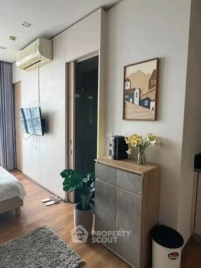 Modern bedroom with stylish decor, air conditioning, and wooden flooring, perfect for urban living.