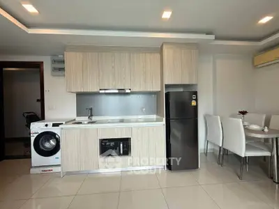 Modern kitchen with sleek cabinetry, integrated appliances, and dining area in open layout.