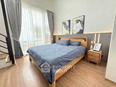 Modern bedroom with stylish decor, large window, and wooden furniture, offering a cozy and inviting atmosphere.