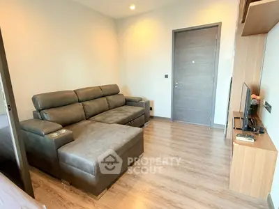 Modern living room with sleek furniture and wooden flooring, perfect for cozy relaxation.