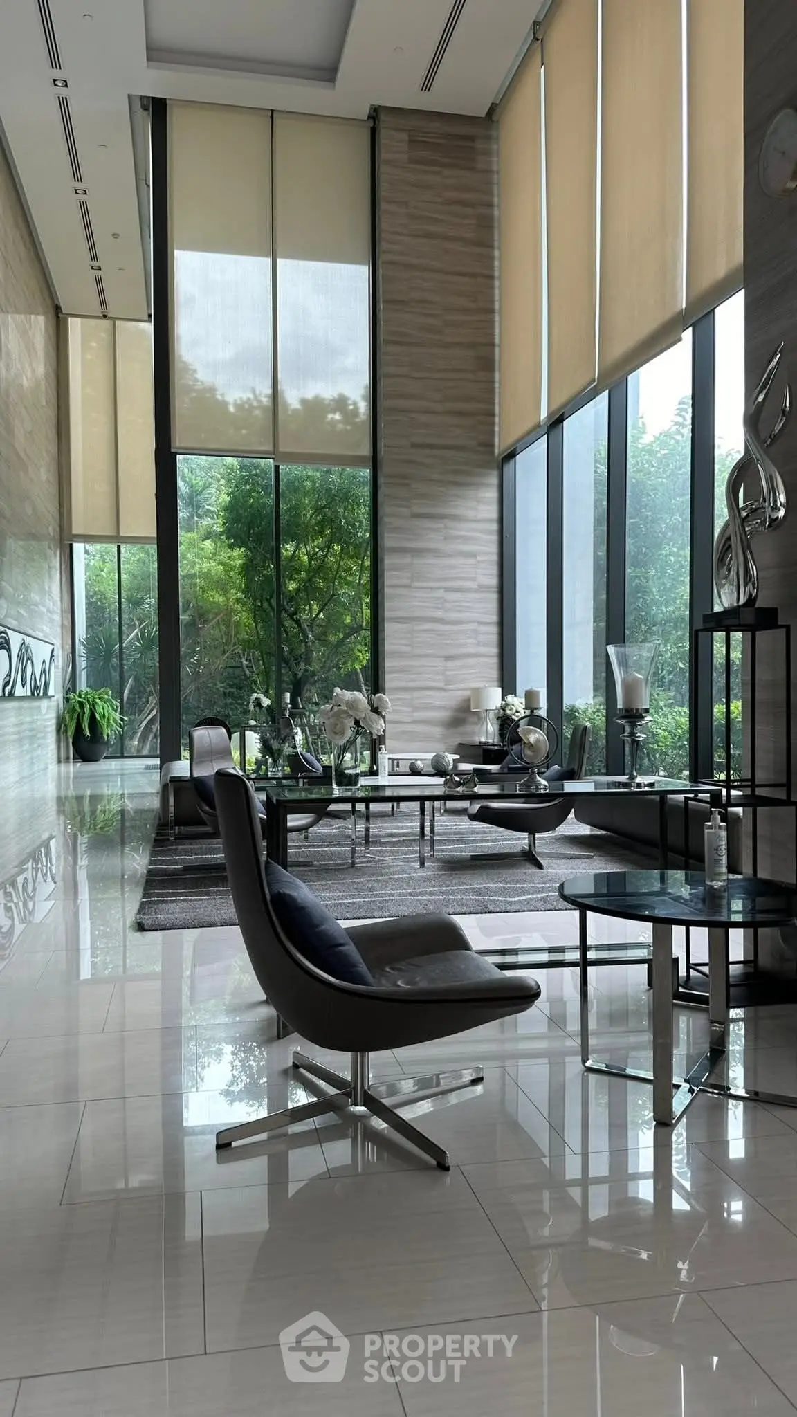 Luxurious modern living room with high ceilings and large windows offering lush garden views.