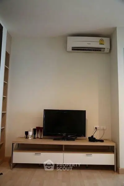 Modern living room with air conditioning and sleek TV setup, perfect for cozy entertainment.