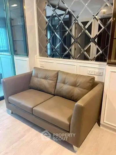 Modern living room with stylish leather sofa and mirrored wall accents