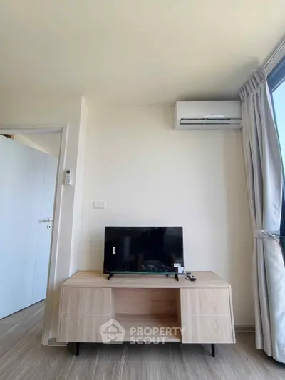 Modern living room with sleek TV setup and air conditioning, perfect for relaxation.