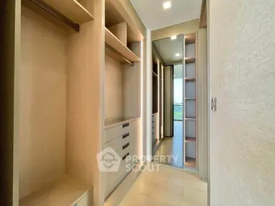 Spacious walk-in closet with wooden shelves and drawers, offering ample storage space and modern design.