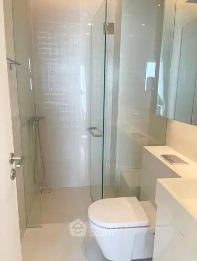 Modern bathroom with glass shower and sleek fixtures in a contemporary apartment.