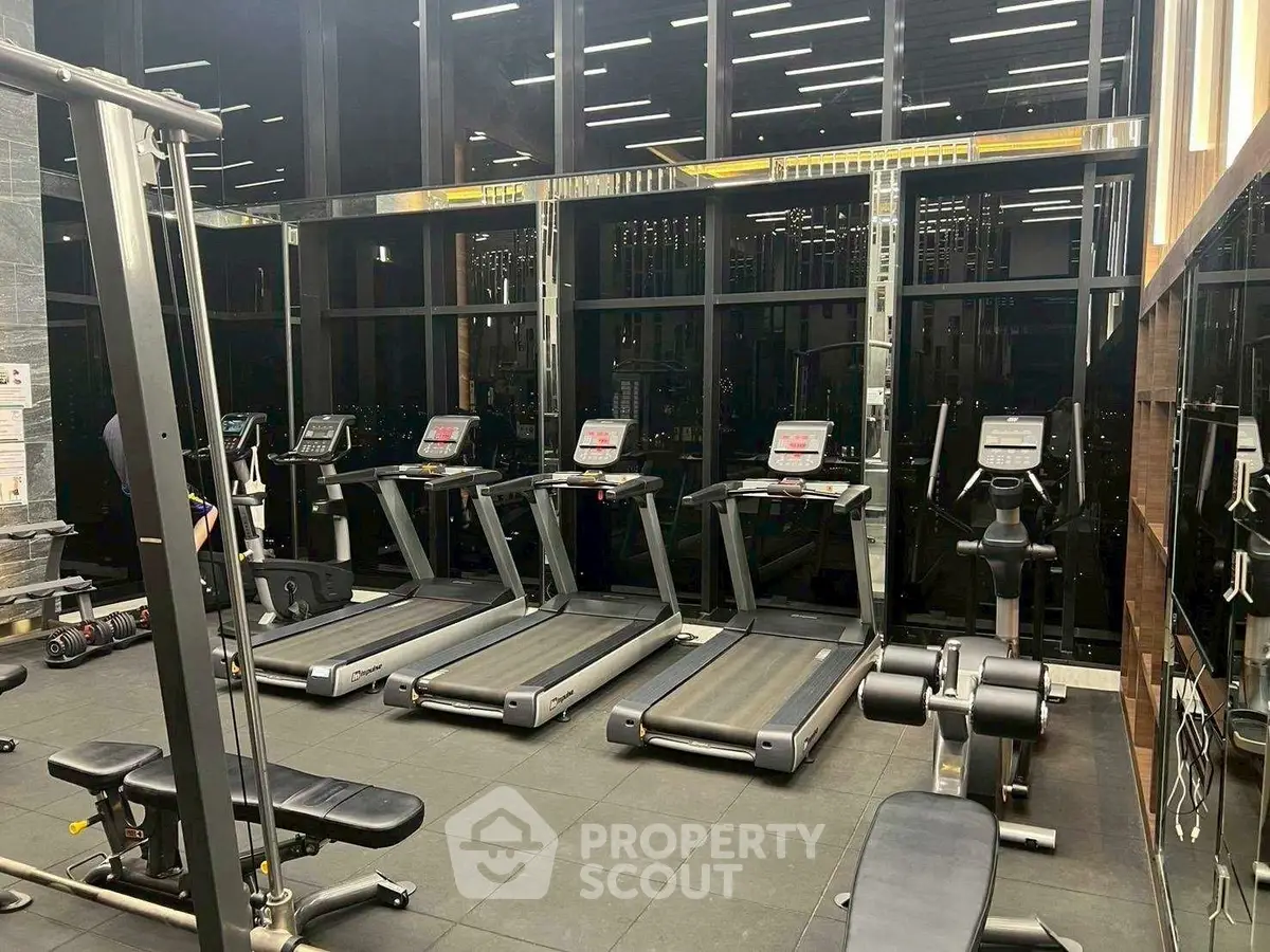 Modern gym with treadmills and fitness equipment in luxury building.