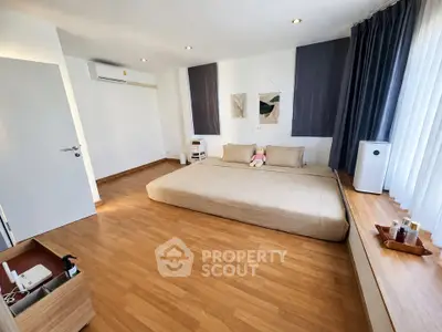 Spacious modern bedroom with minimalist decor and large windows for natural light.