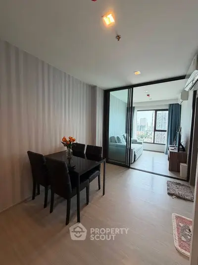 Modern open-plan living and dining area with city view, featuring sleek furniture and elegant decor.