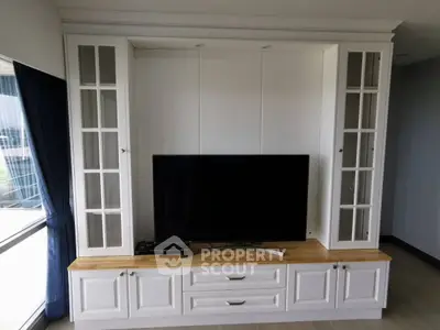 Elegant living room with built-in white cabinetry and modern flat-screen TV, perfect for stylish entertainment.
