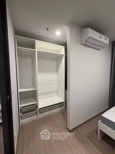 Modern bedroom with built-in closet and air conditioning unit, perfect for comfortable living.