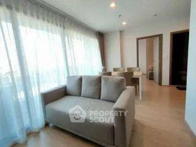 Bright and airy living room with modern furniture and large windows in a stylish apartment.