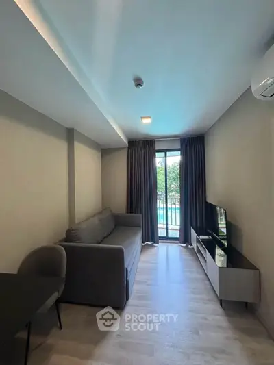 Modern living room with sleek furniture and pool view balcony in a stylish apartment.