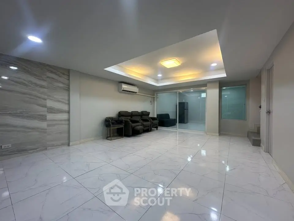 Spacious modern living room with elegant marble flooring and cozy seating area.
