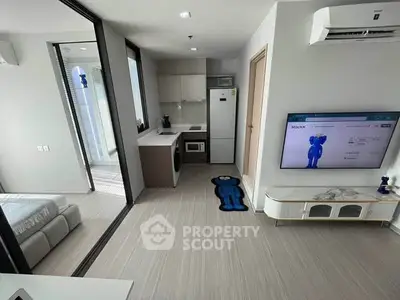 Modern apartment interior with open layout, featuring a cozy living area, kitchen, and bedroom.