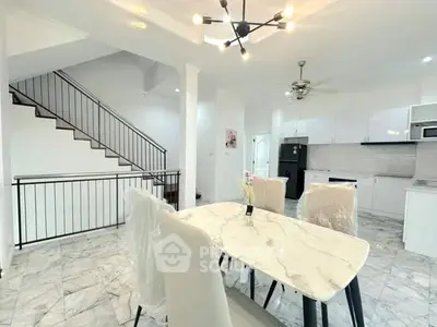 Modern dining area with marble table and sleek kitchen in open layout