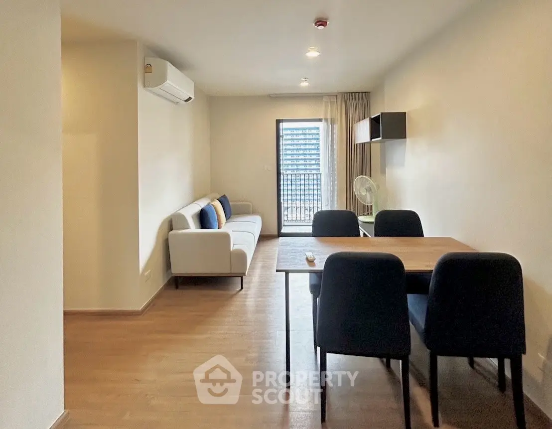Modern living room with sleek furniture and balcony access in a stylish apartment.