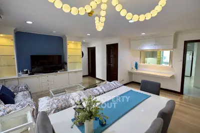 Spacious living room with elegant decor and modern lighting in a stylish apartment.