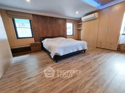 Spacious modern bedroom with wooden flooring and stylish decor