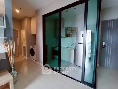 Modern apartment with sleek kitchen and washing machine, ideal for urban living.