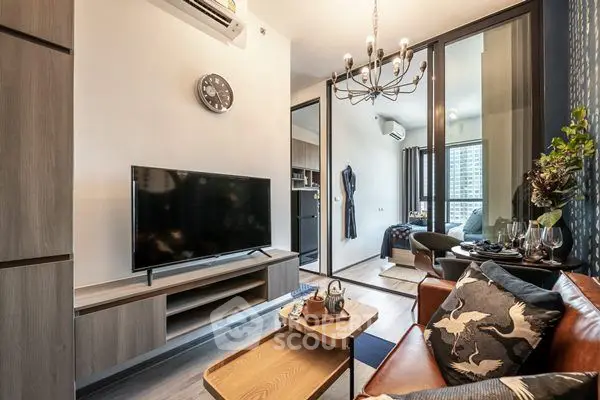 Modern living room with stylish decor and open layout, featuring a cozy seating area and wall-mounted TV.