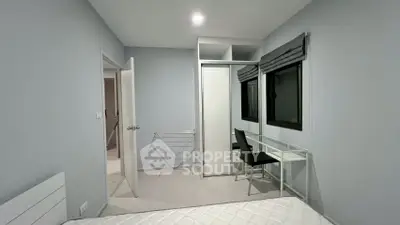 Modern bedroom with minimalist design, featuring a bed, desk, and wardrobe in a bright, airy space.