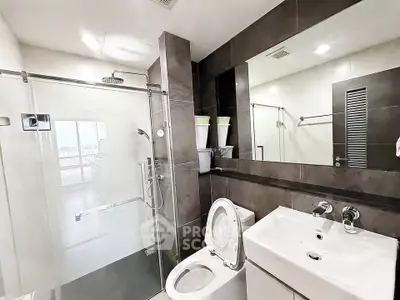 Modern bathroom with glass shower and sleek fixtures in a contemporary apartment.