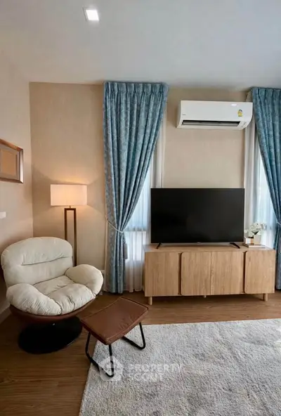 Stylish living room with modern furniture, large TV, and elegant curtains, perfect for relaxation and entertainment.