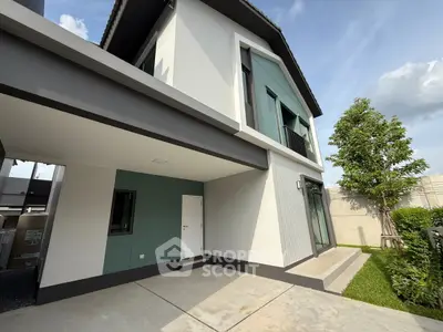 Modern two-story house with sleek design and lush green garden