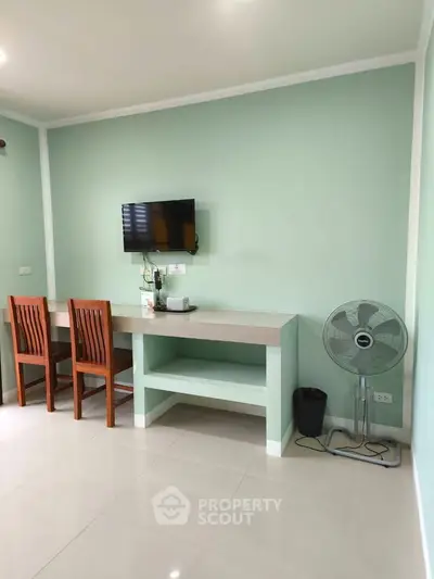 Modern study area with wall-mounted TV and fan, ideal for productivity.