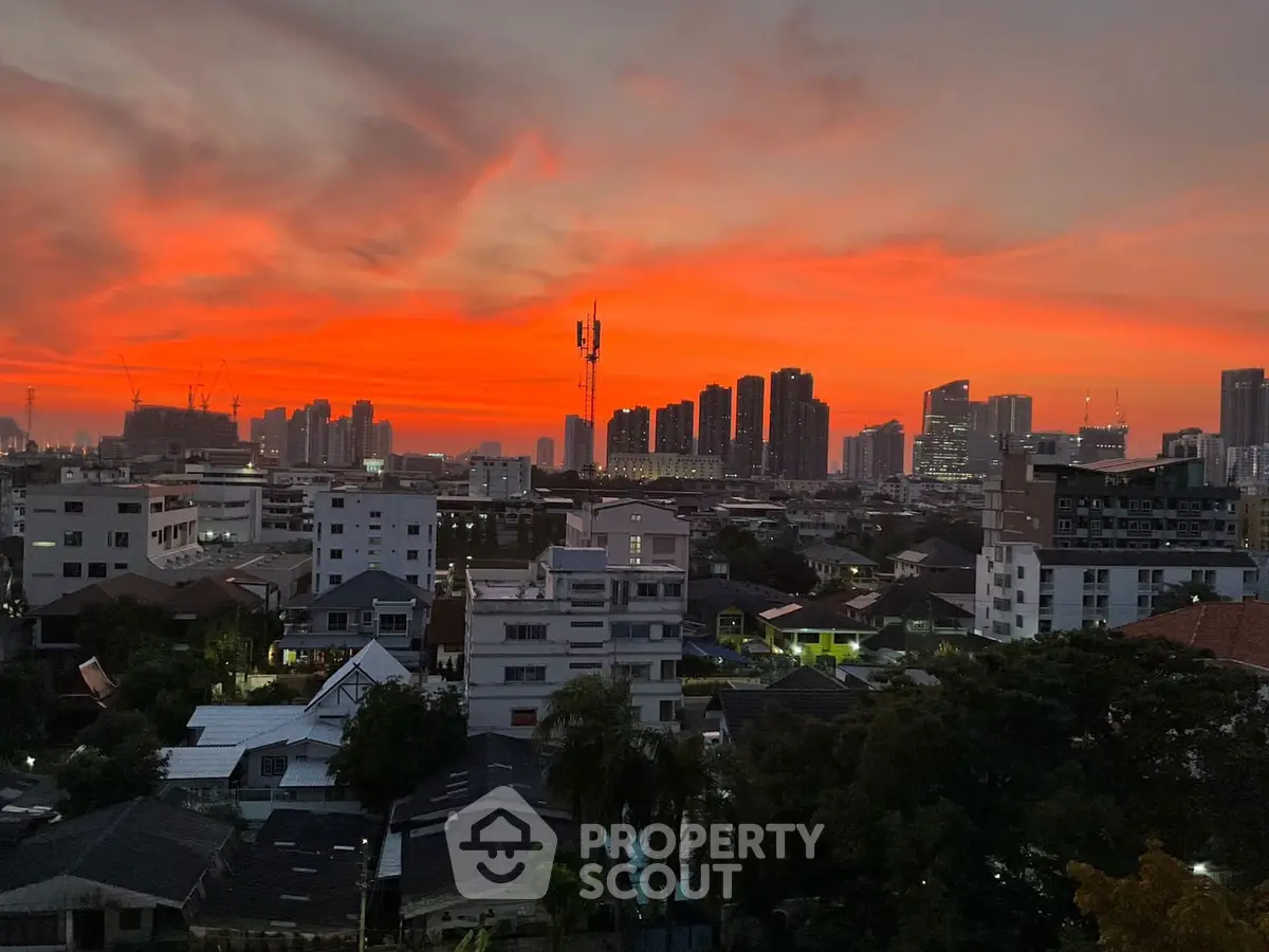 Stunning urban skyline view at sunset with vibrant orange sky over city buildings.