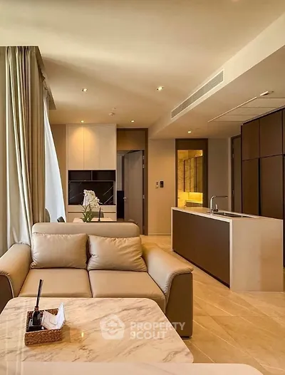 Luxurious modern living room with elegant furnishings and open kitchen layout.