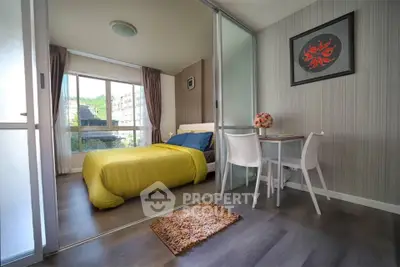 Modern bedroom with bright yellow bedding and stylish decor, featuring a cozy study nook and large windows.