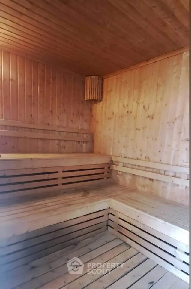 Luxurious wooden sauna room with elegant bench seating in a premium real estate property.