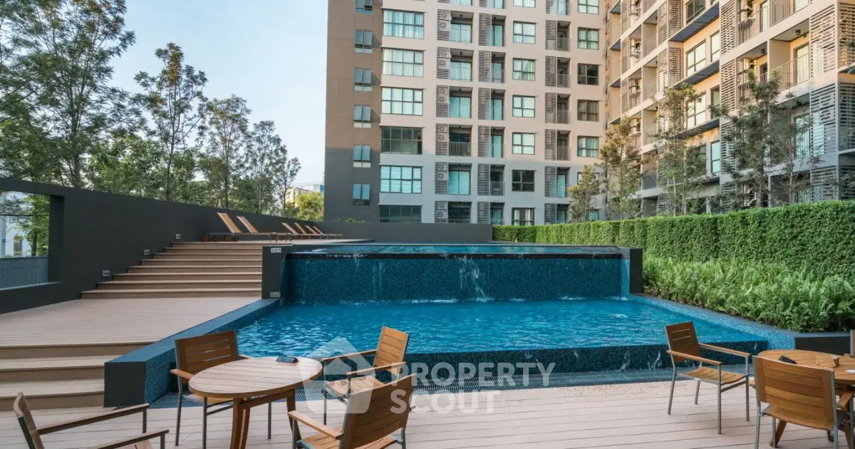 Modern apartment complex with inviting pool and outdoor seating area.