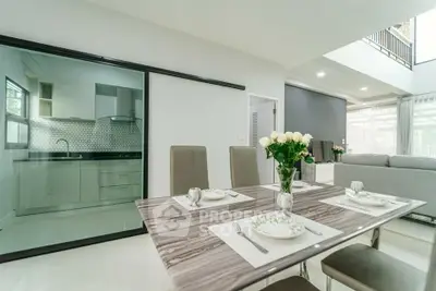 Modern dining area with elegant table setting and view into sleek kitchen