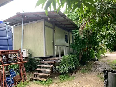 Unique small modular home with elevated porch and lush greenery