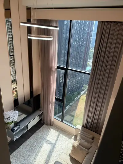 Luxurious high-rise living room with floor-to-ceiling windows and stunning city view.