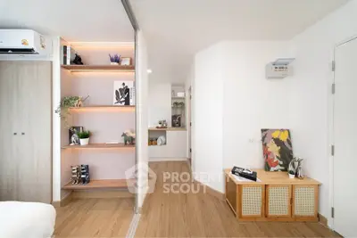 Modern living space with stylish decor and wooden flooring, featuring open shelving and contemporary design.
