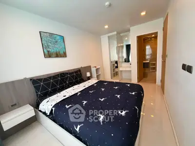 Modern bedroom with stylish decor and ensuite bathroom in a contemporary apartment.
