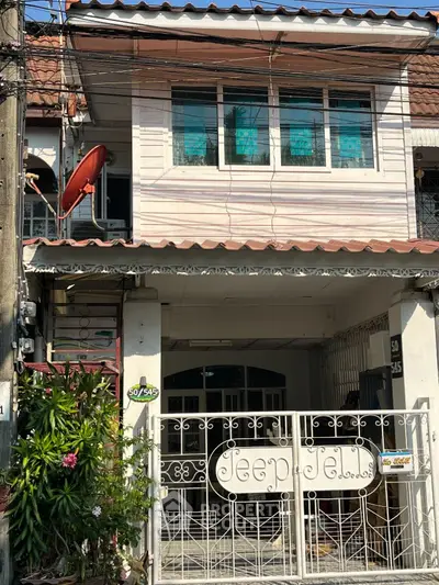 Charming two-story townhouse with secure wrought iron gate and cozy balcony, nestled in a vibrant neighborhood, awaiting your personal touch.