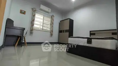 Spacious bedroom with modern furniture and air conditioning in a well-lit apartment.