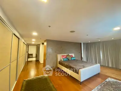 Spacious bedroom with elegant decor and wooden flooring